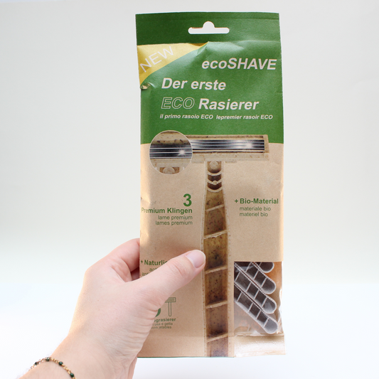 Hand hält eine Verpackung von Einwegrasierern von green-goose mit Aufschrift Eco Rasierer