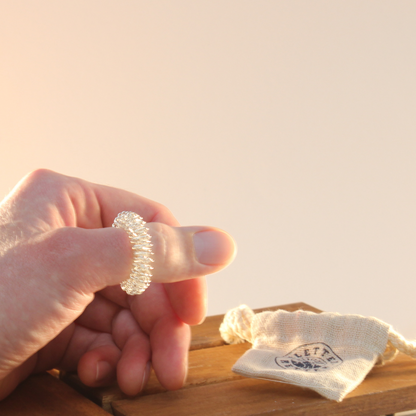 Ein am Daumen angezogener Fingermassagering der Marke Kletterretter